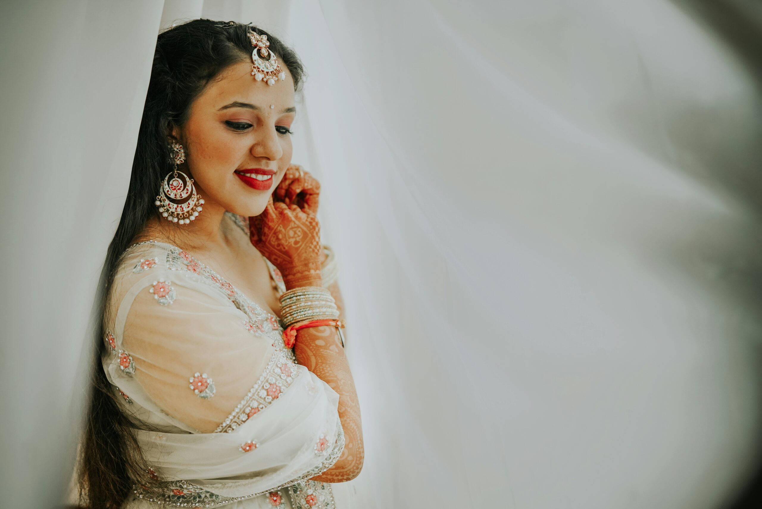 Bride smiling with flawless makeup under soft lighting