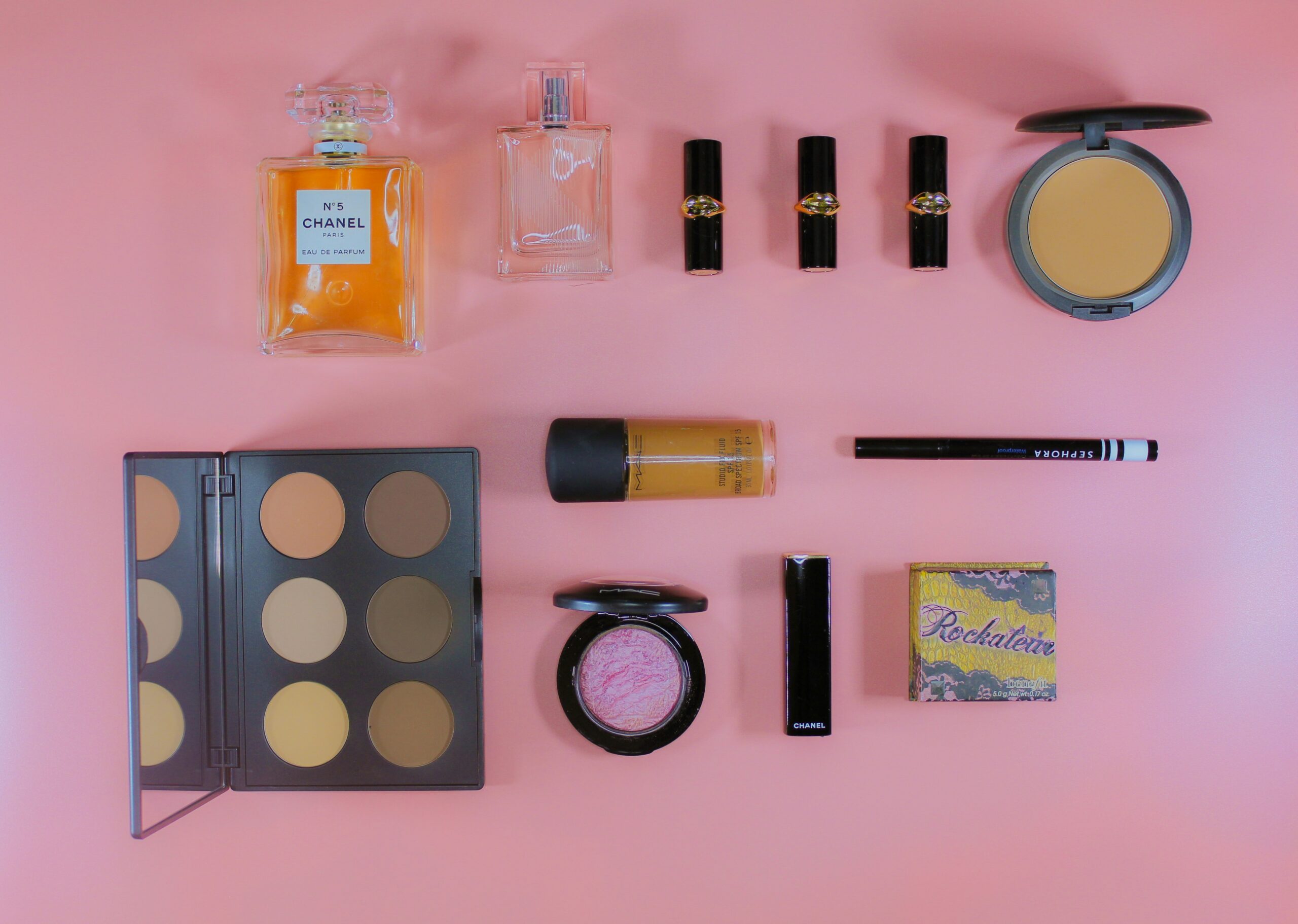 Close-up image of a professional makeup artist's kit filled with branded products.