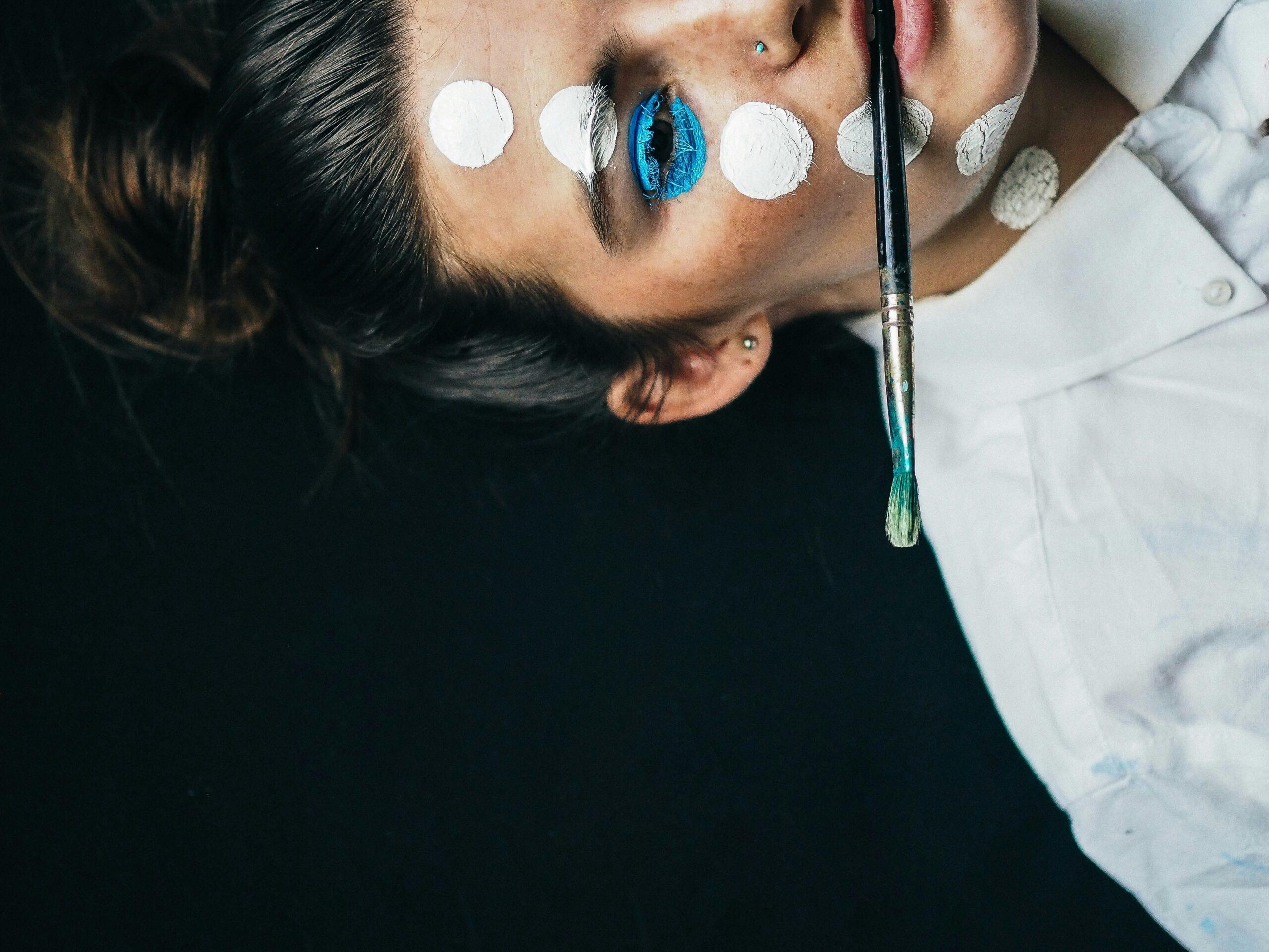 Model applying eyeliner with painter's tape as a guide