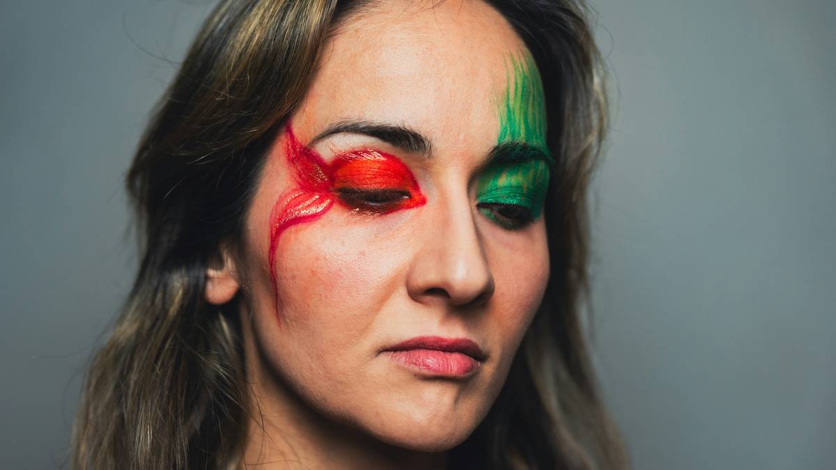 A person holding their head in frustration next to messy makeup products.
