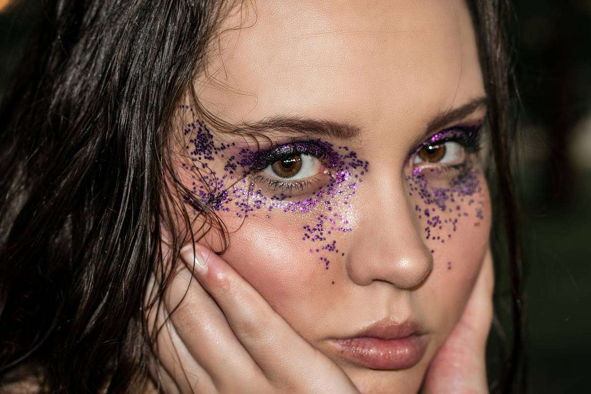 Professional makeup artist applying colorful eyeshadow on a model backstage